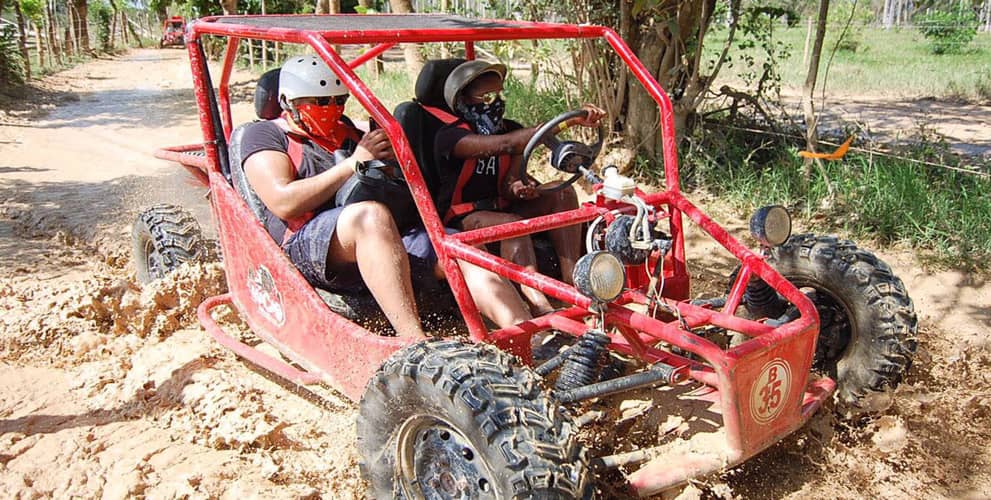 Couple driving an ATV on a muddy road