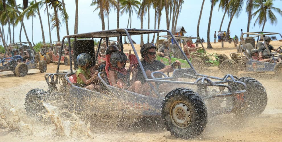 Family driving an ATV on a muddy road