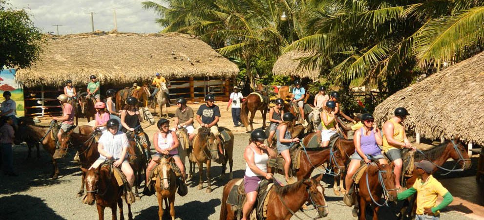 horseback riding group stopping at a village in punta cana
