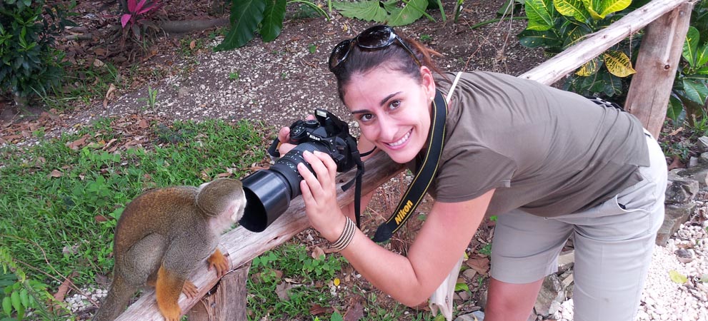 Girl taking a close up picture of a monkey