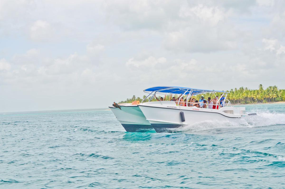 Tourist touring Saona Island waters on a twin hull boat