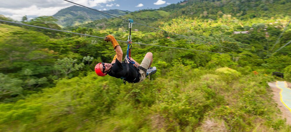 tourist enjoying the zip line ride through the dominican mountains