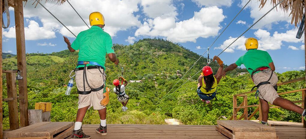 staff launching tourists in zip line gear use