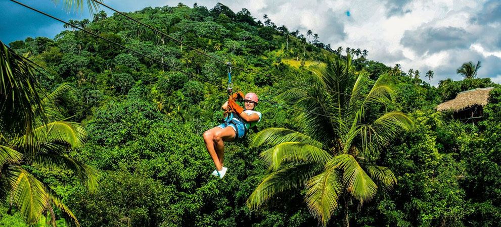 tourist enjoying the zip line ride through the dominican mountains